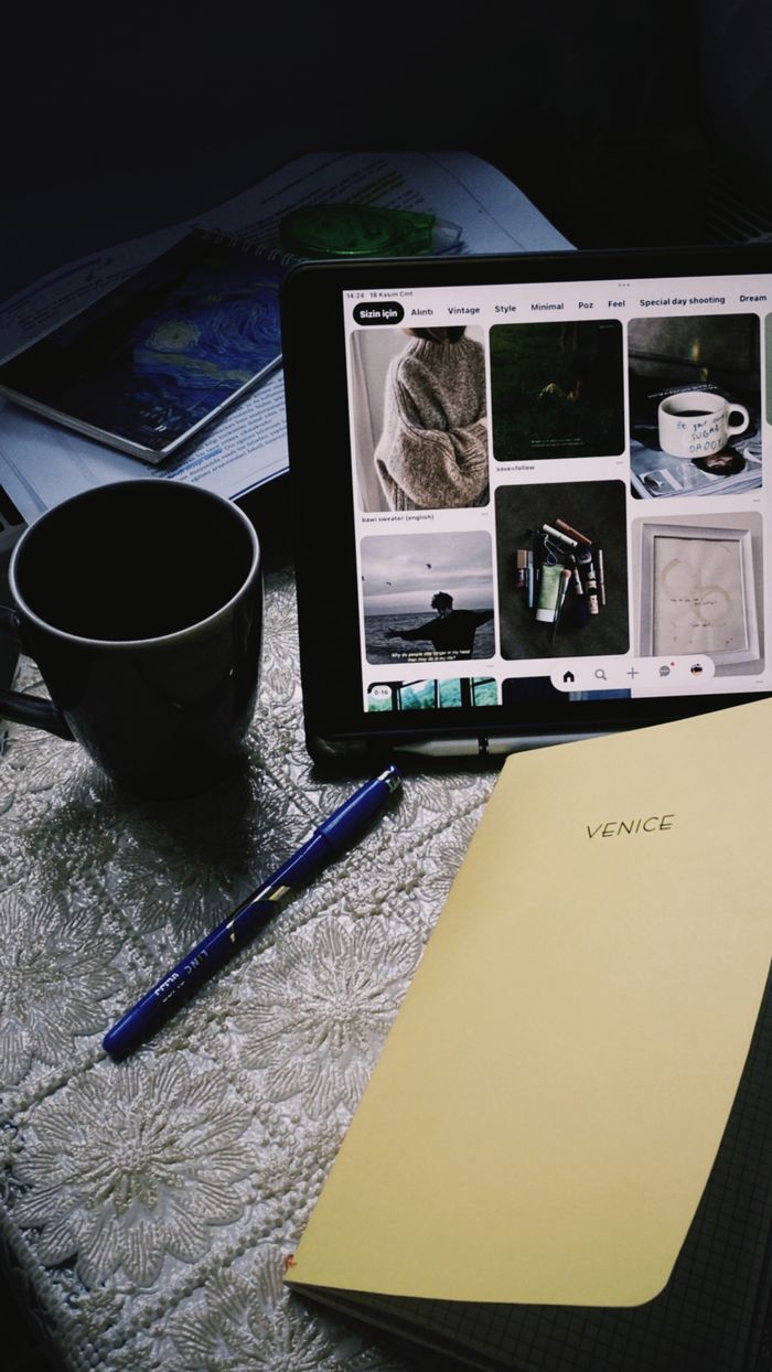 A cozy office setting featuring a tablet, notebook, and mug on a textured surface.