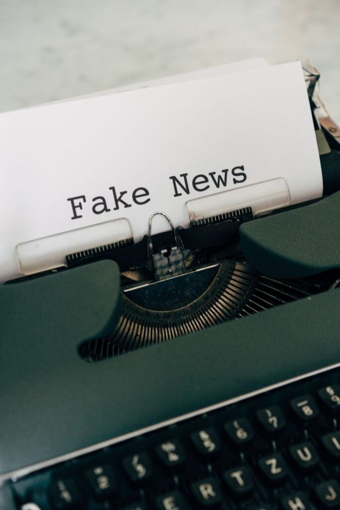 Close-up of vintage typewriter with 'Fake News' typed on paper.